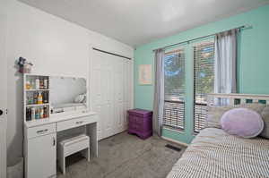 Carpeted bedroom featuring a closet and a textured ceiling