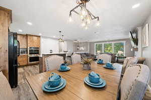 Dining room with an inviting chandelier and light hardwood / wood-style floors