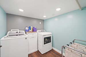 Clothes washing area featuring dark wood-type flooring and washing machine and clothes dryer