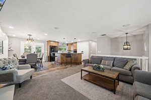 Living room featuring a textured ceiling, light hardwood / wood-style flooring, and a notable chandelier