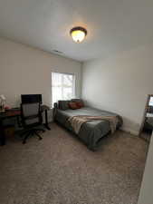 Bedroom with a textured ceiling and carpet floors