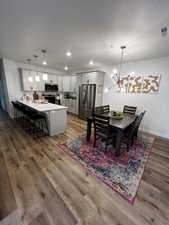 Dining area with hardwood / wood-style floors, a chandelier, and sink