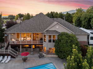 Back house at dusk featuring a patio