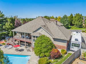 Back of property with a swimming pool side deck and a patio