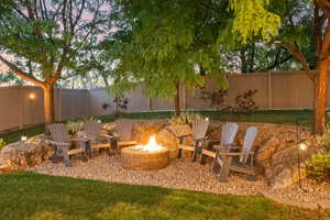 Yard at dusk with an outdoor fire pit and a patio