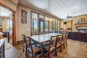 Dining area featuring a fireplace, ceiling fan, and tile patterned floors