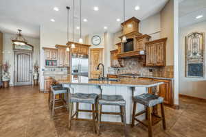 Kitchen featuring tasteful backsplash, appliances with stainless steel finishes, and a kitchen island with sink