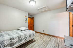 Bedroom with light hardwood / wood-style flooring