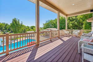 Wooden terrace featuring a fenced in pool