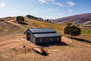 View of home's exterior featuring a rural view, a mountain view, and an outbuilding