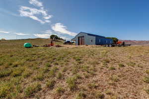 View of yard featuring a garage, a rural view, and an outdoor structure