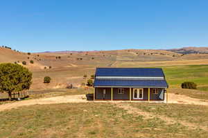 View of front of home featuring a rural view, an outdoor structure, and a mountain view