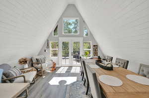 Interior space with lofted ceiling, plenty of natural light, hardwood / wood-style floors, and french doors