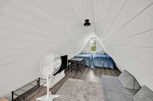 Bedroom with lofted ceiling and wood-type flooring