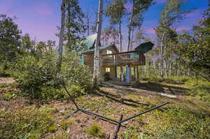 Back house at dusk featuring a deck