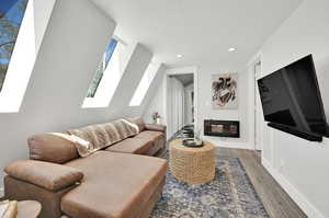 Living room with dark wood-type flooring and a skylight