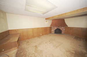 Additional living space with wood walls and a brick fireplace