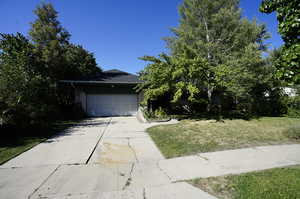 View of front of property featuring a garage and a front lawn