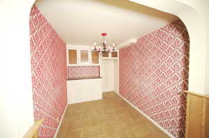 Interior space with a notable chandelier and light parquet flooring