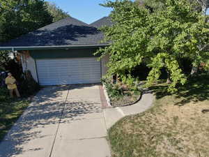 View of side of home featuring a yard and a garage