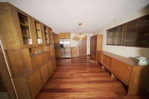 Dining space featuring a textured ceiling, dark wood-type flooring, and an inviting chandelier