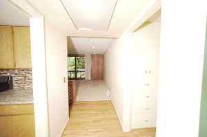 Hallway with light hardwood / wood-style floors