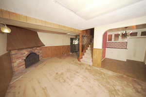 Unfurnished living room featuring a fireplace, a notable chandelier, and parquet floors