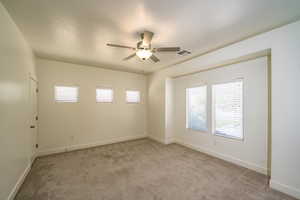 Spare room featuring light colored carpet and ceiling fan