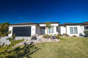 View of front of house featuring a front yard and a garage