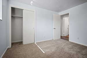 Unfurnished bedroom with a closet and carpet