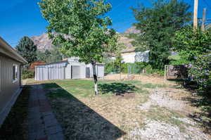 View of yard with a mountain view and a storage unit