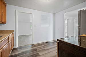 Interior space featuring stainless steel refrigerator and wood-type flooring