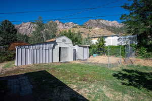 View of yard featuring a mountain view and a storage unit