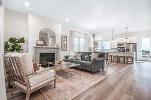 Living room with light wood-type flooring and a notable chandelier