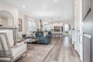 Living room with a chandelier, a wealth of natural light, and light hardwood / wood-style floors