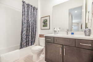 Full bathroom featuring vanity, toilet, and shower / bath combo with shower curtain