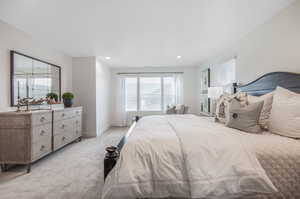 Carpeted bedroom featuring multiple windows