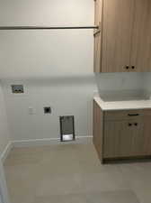 Laundry area featuring hookup for a washing machine, cabinets, electric dryer hookup, and light tile patterned flooring