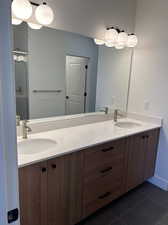 Master Bathroom featuring vanity, double sink, an enclosed shower, and tile patterned floors