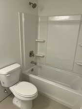 Downstairs Full Bathroom featuring bathtub / shower combination, toilet, and tile patterned floors