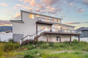 Back house at dusk featuring a balcony