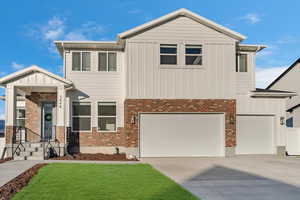 View of front of property with a garage and a front lawn