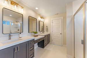 Bathroom with vanity, a shower with shower door, and tile patterned floors