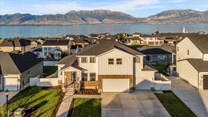 View of front of property with a water and mountain view and a garage