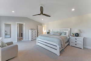 Carpeted bedroom featuring lofted ceiling, ceiling fan, and connected bathroom