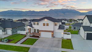 View of front facade featuring a garage, a yard, and a water and mountain view