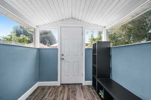 Exterior space with lofted ceiling and dark hardwood / wood-style flooring