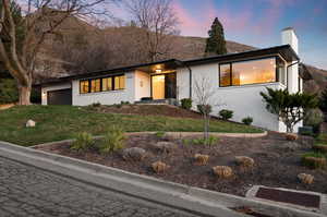 View of front facade featuring a yard and a garage