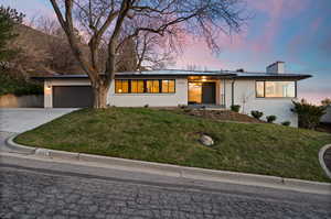 Single story home featuring a yard and a garage