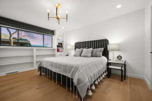 Bedroom featuring wood-type flooring and a chandelier